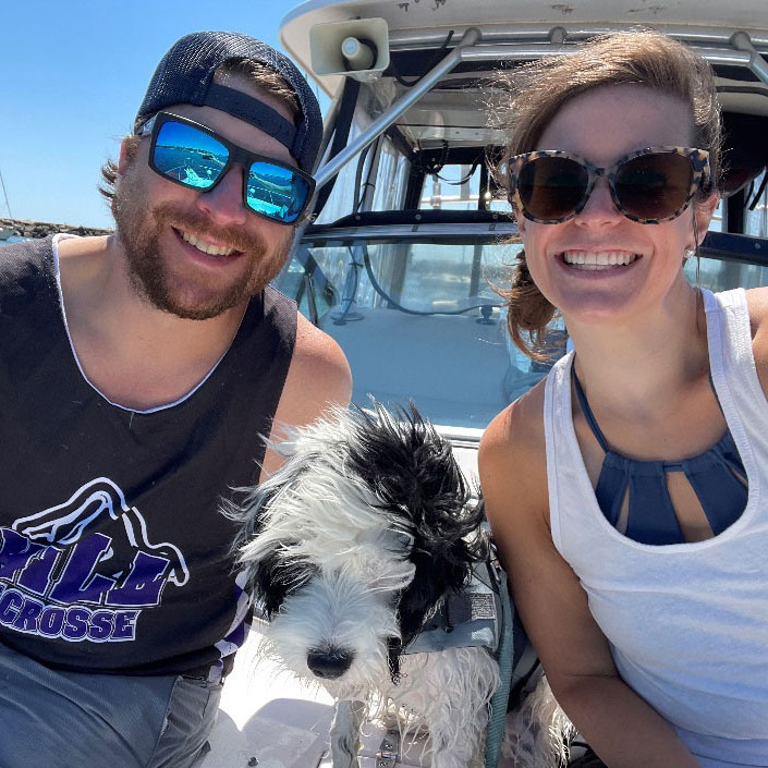 a couple and a dog on a boat
